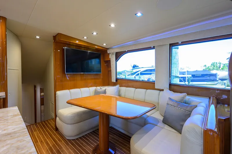 Slide: The Image of Luxurious interior of 2004 Viking 65 Enclosed Bridge yacht with dining area and TV. - 25