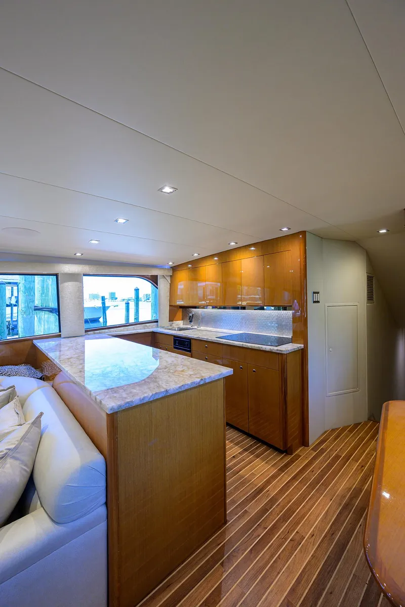 Slide: The Image of Luxurious interior of 2004 Viking 65 Enclosed Bridge yacht with modern kitchen and seating area. - 22