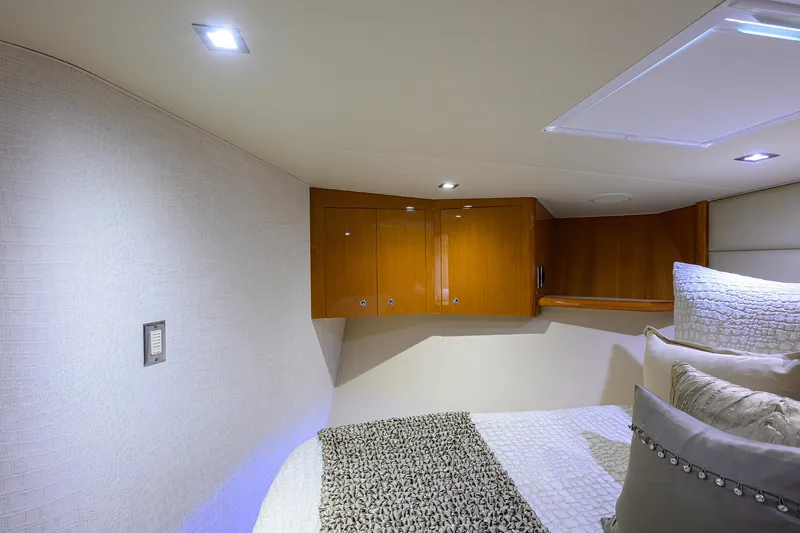 Slide: The Image of Interior cabin of 2004 Viking 65 Enclosed Bridge yacht with wooden cabinets and cozy bedding. - 44