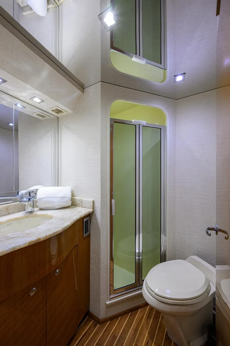 Slide: The Image of 2004 Viking 65 Enclosed Bridge yacht bathroom with shower, sink, and toilet. - 46