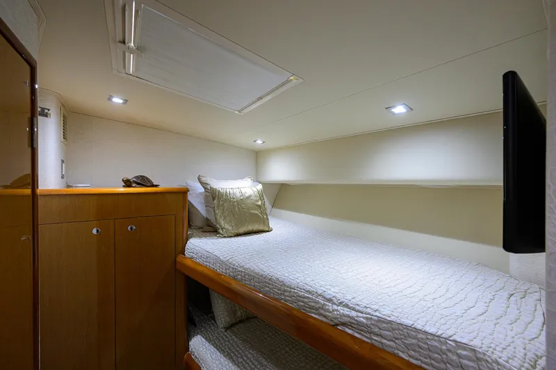 Slide: The Image of 2004 Viking 65 Enclosed Bridge w/Tower cabin interior with single bed and storage. - 50