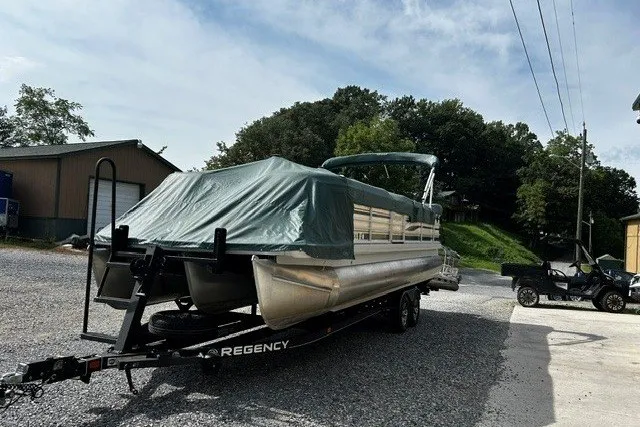 Slide: The Image of Pontoon boat Godfrey SANPAN 2500 (2005) on trailer, covered, parked outdoors. - 17