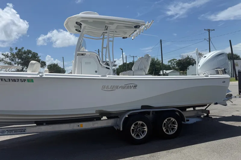 Slide: The Image of 2019 Blue Wave 2800 Pure Hybrid boat on trailer under clear sky. - 2