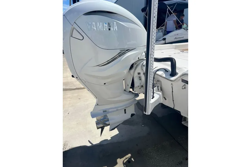 Slide: The Image of 2019 Blue Wave 2800 Pure Hybrid boat with Yamaha outboard motor, docked outdoors. - 4