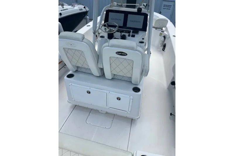 Slide: The Image of 2019 Blue Wave 2800 Pure Hybrid boat interior with Garmin displays and cushioned seating. - 13
