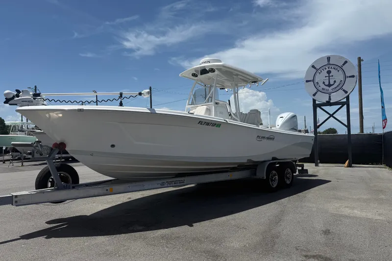 Slide: The Image of 2019 Blue Wave 2800 Pure Hybrid boat on trailer under clear sky. - 5