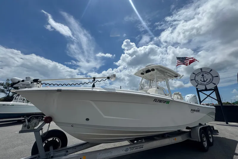 Slide: The Image of 2019 Blue Wave 2800 Pure Hybrid boat on trailer under a cloudy sky. - 6