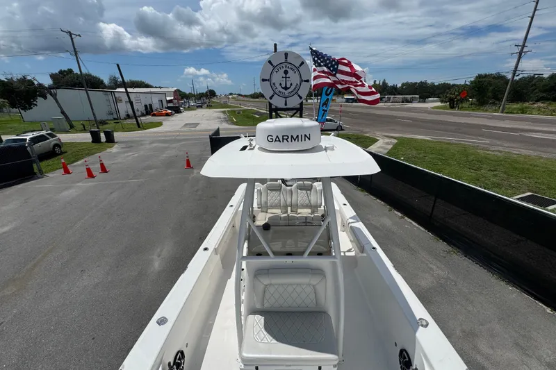 Slide: The Image of 2019 Blue Wave 2800 Pure Hybrid boat with Garmin equipment, docked near a road with American flags. - 53