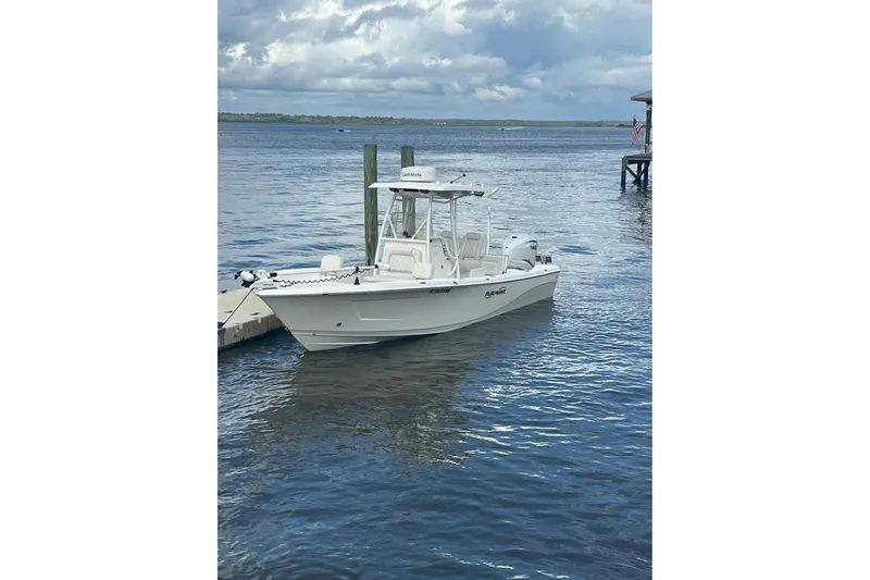 Slide: The Image of 2019 Blue Wave 2800 Pure Hybrid boat docked on a calm, cloudy waterfront. - 1
