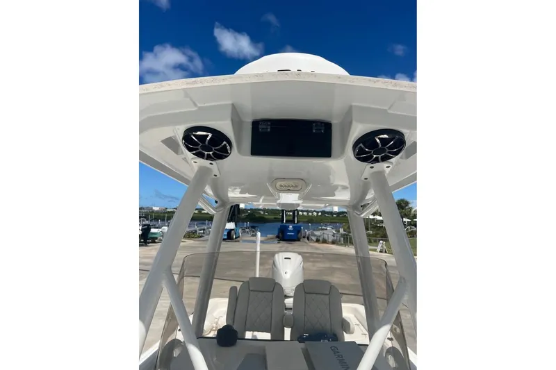 Slide: The Image of 2019 Blue Wave 2800 Pure Hybrid boat interior with speakers and seating under a clear blue sky. - 10