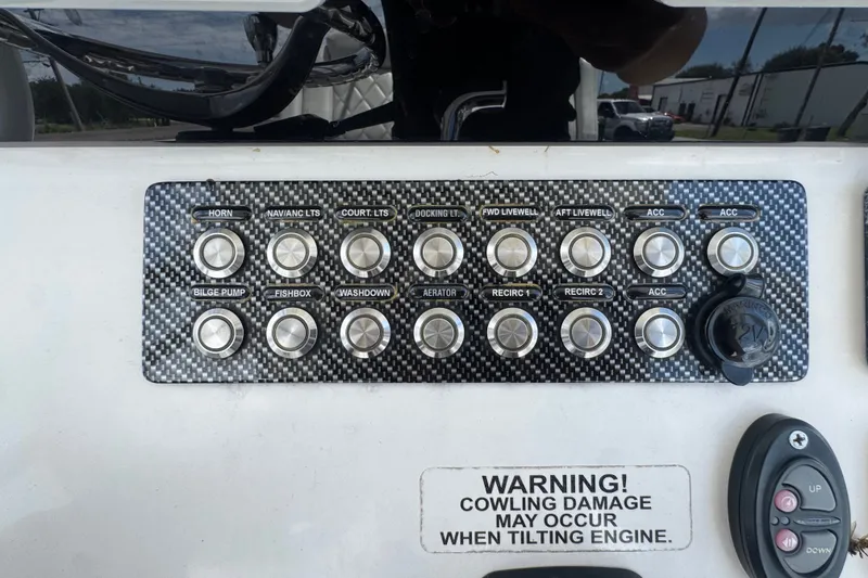 Slide: The Image of Control panel of a 2019 Blue Wave 2800 Pure Hybrid boat with various switches and warning label. - 78