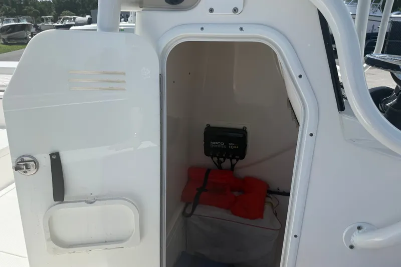 Slide: The Image of Open storage compartment on 2019 Blue Wave 2800 Pure Hybrid boat, featuring safety equipment. - 63