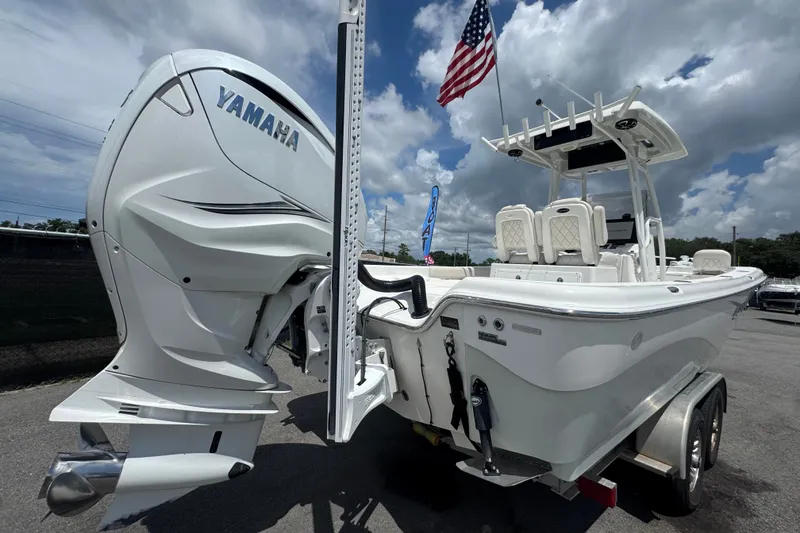 Slide: The Image of 2019 Blue Wave 2800 Pure Hybrid boat with Yamaha engine, parked under cloudy sky. - 19