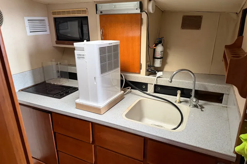Slide: The Image of 1967 Hatteras 41 Convertible yacht kitchen with sink, stove, and microwave. - 12