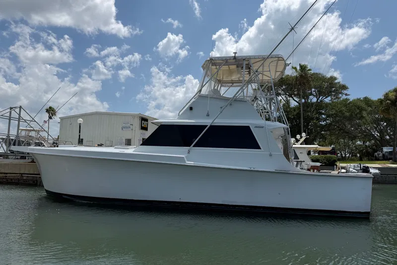The Image of 1967 Hatteras 41 Convertible yacht docked under a partly cloudy sky. - 0