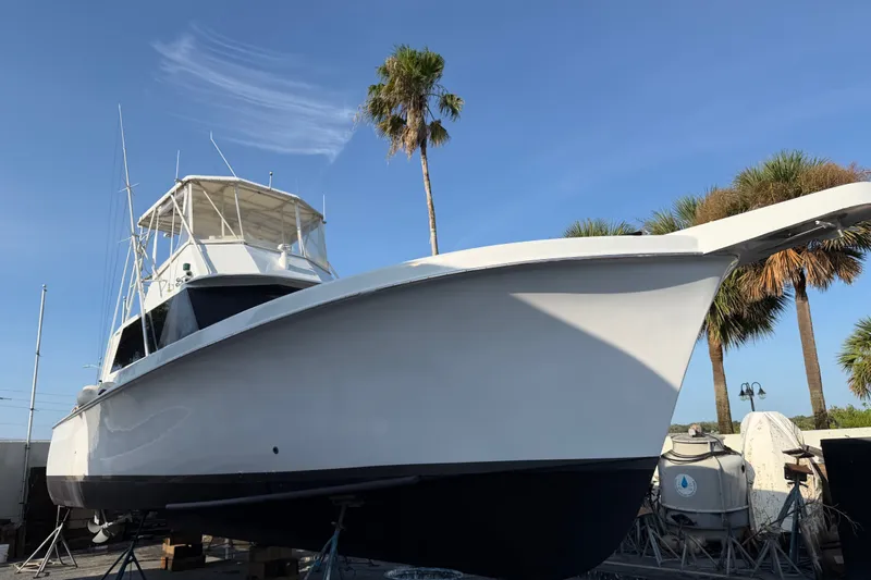 Slide: The Image of 1967 Hatteras 41 Convertible boat on dry dock with palm trees in background. - 18