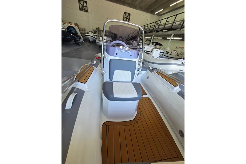 Slide: The Image of The image shows the cockpit of a Gala Viking V360 boat with a cushioned seat and wood flooring. - 8