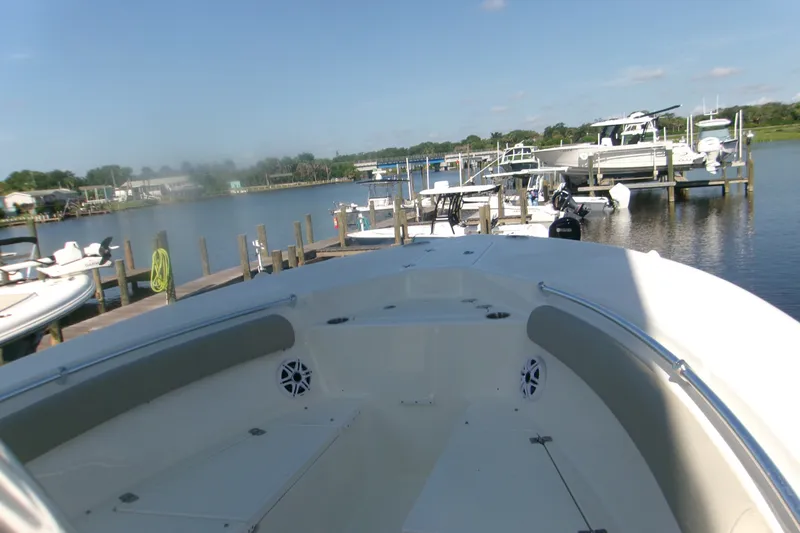 Slide: The Image of 2027 Key West 244 Center Console boat docked at a marina under clear skies. - 14
