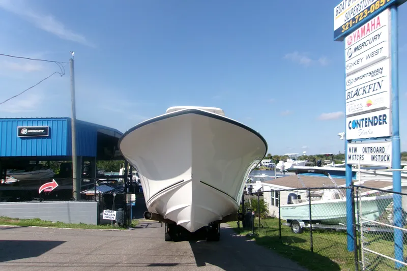 Slide: The Image of 2027 Key West 244 Center Console boat at dealership with various brand signs. - 21