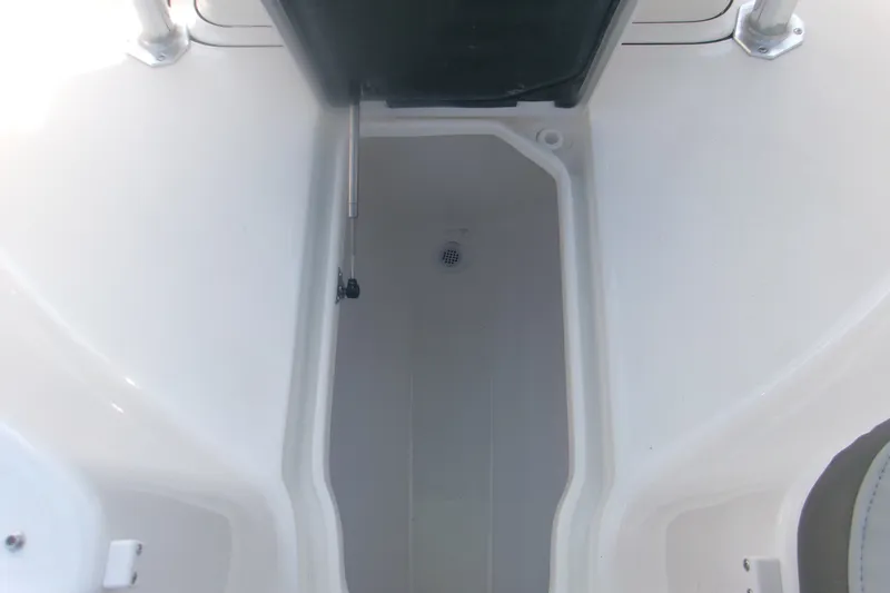 Slide: The Image of 2027 Key West 244 Center Console storage compartment, open and empty. - 19