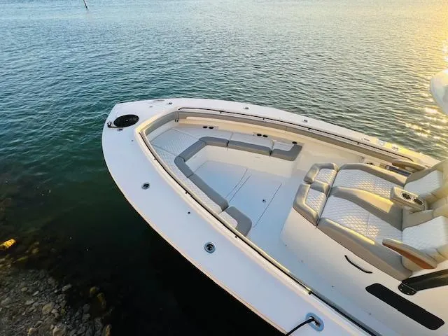 Slide: The Image of 2024 Regulator 41 boat with spacious seating, docked on calm water. - 16