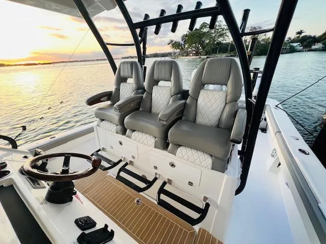 Slide: The Image of 2024 Regulator 41 boat interior with luxury seating at sunset on the water. - 27