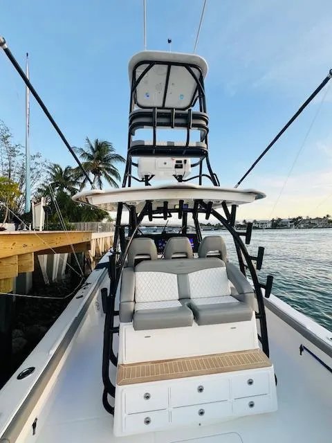 Slide: The Image of 2024 Regulator 41 boat with tower, docked by the water, featuring seating and storage. - 34