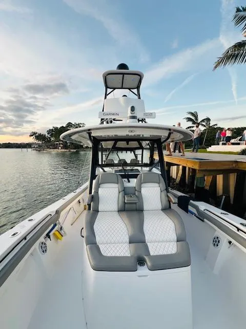 Slide: The Image of 2024 Regulator 41 boat with sleek seating, docked by a scenic waterfront. - 24