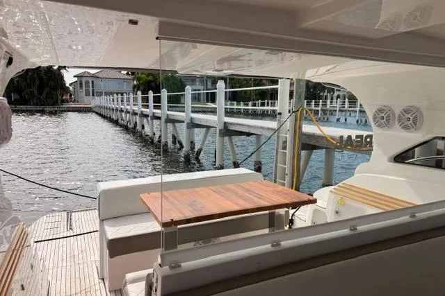 Slide: The Image of Luxury yacht interior with wooden table, overlooking a serene waterfront dock. Real 40 HT Luxury 2025. - 16