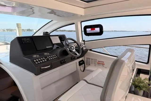 Slide: The Image of 2025 Real 40 HT Luxury yacht interior with modern dashboard and scenic water view. - 17