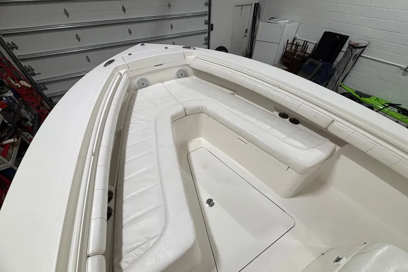 Slide: The Image of 2015 Regulator 23 boat interior with white cushioned seating in a garage setting. - 24