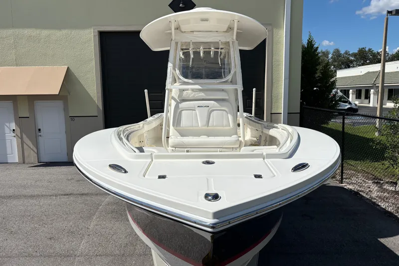 Slide: The Image of 2015 Regulator 23 boat, white exterior, parked outdoors near a building. - 12