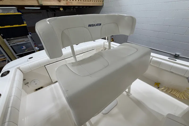 Slide: The Image of 2015 Regulator 23 boat interior with white seating and storage compartments. - 16