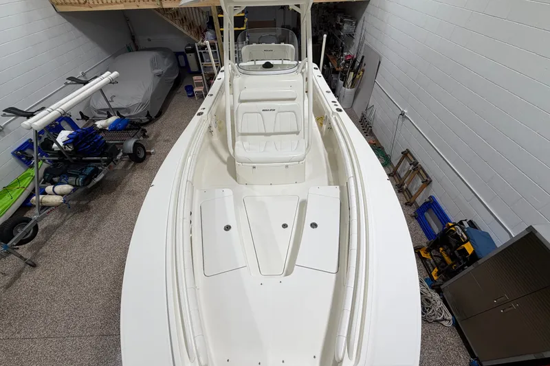 Slide: The Image of 2015 Regulator 23 boat in a garage, showcasing spacious deck and seating. - 20