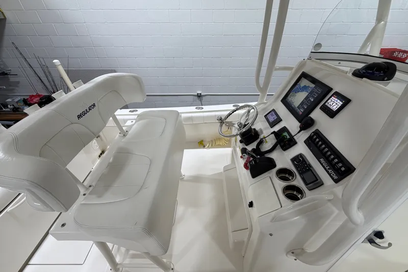 Slide: The Image of 2015 Regulator 23 boat interior with helm, steering wheel, and electronic controls. - 14