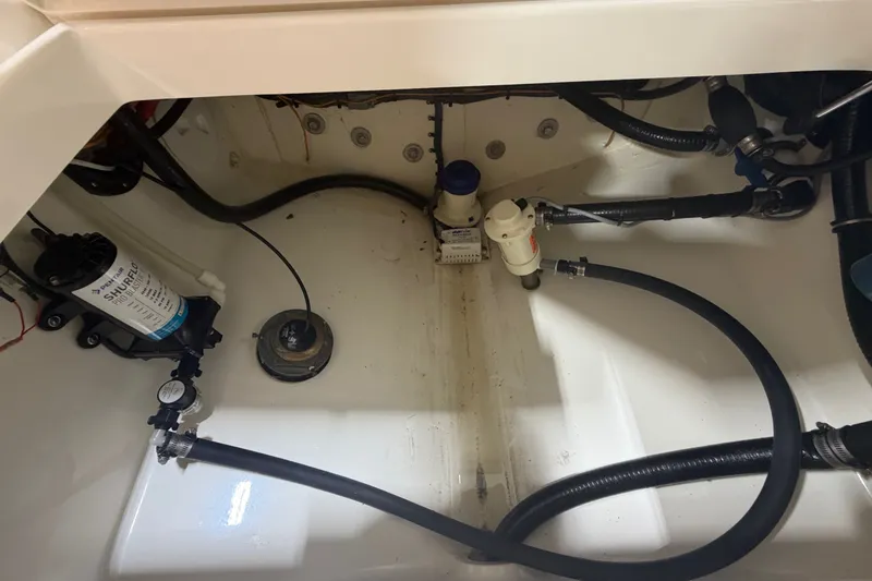 Slide: The Image of 2015 Regulator 23 boat bilge area with hoses and pump components. - 39