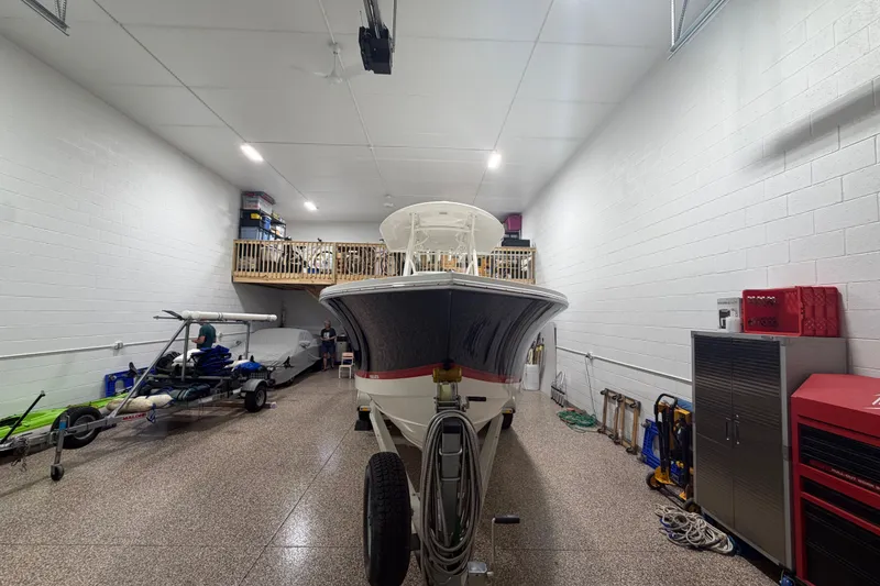 Slide: The Image of 2015 Regulator 23 boat stored in a spacious garage with equipment and tools. - 9