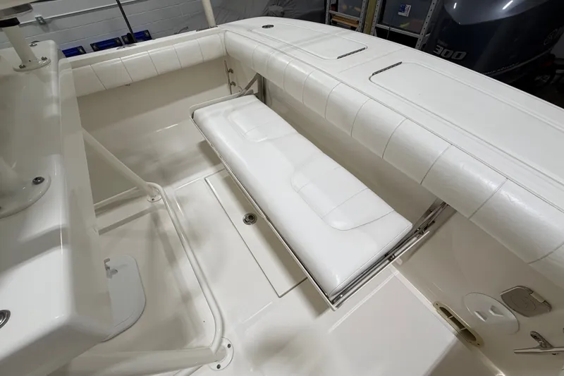 Slide: The Image of 2015 Regulator 23 boat interior with white cushioned seating and storage area. - 18