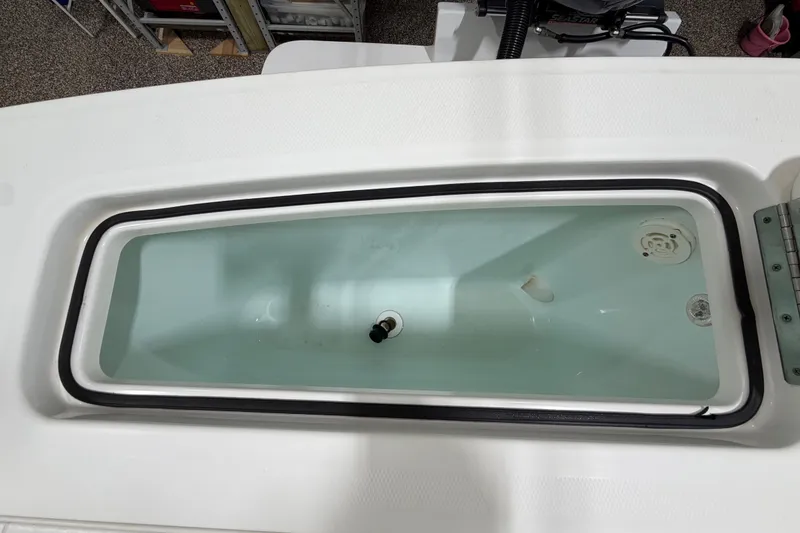 Slide: The Image of Livewell compartment on a 2015 Regulator 23 boat, featuring a clean, white interior. - 37