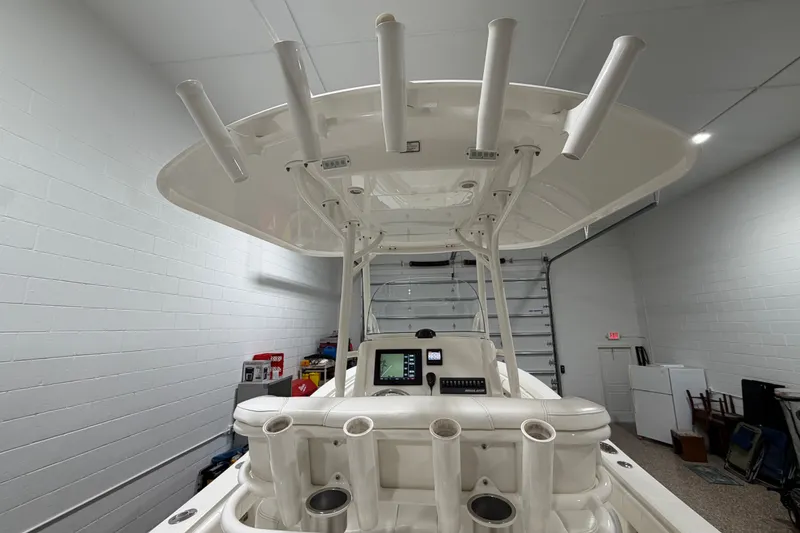 Slide: The Image of 2015 Regulator 23 boat interior with rod holders and navigation equipment in a garage. - 19