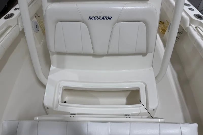 Slide: The Image of 2015 Regulator 23 boat interior with white seating and storage compartment. - 23