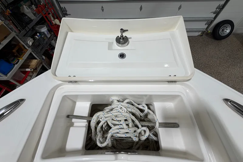 Slide: The Image of 2015 Regulator 23 boat anchor locker with rope and cleat in a garage setting. - 36