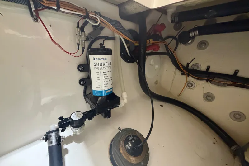 Slide: The Image of Interior view of a 2015 Regulator 23 boat showing wiring and a Shurflo pump. - 45