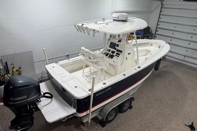 The Image of 2015 Regulator 23 boat in garage, featuring Yamaha outboard motor and Garmin equipment. - 0