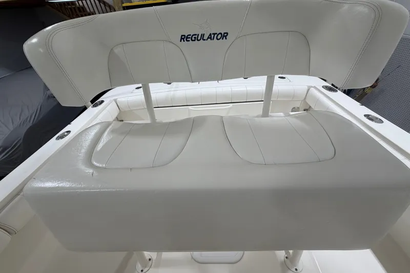 Slide: The Image of 2015 Regulator 23 boat seating with white upholstery and logo. - 15