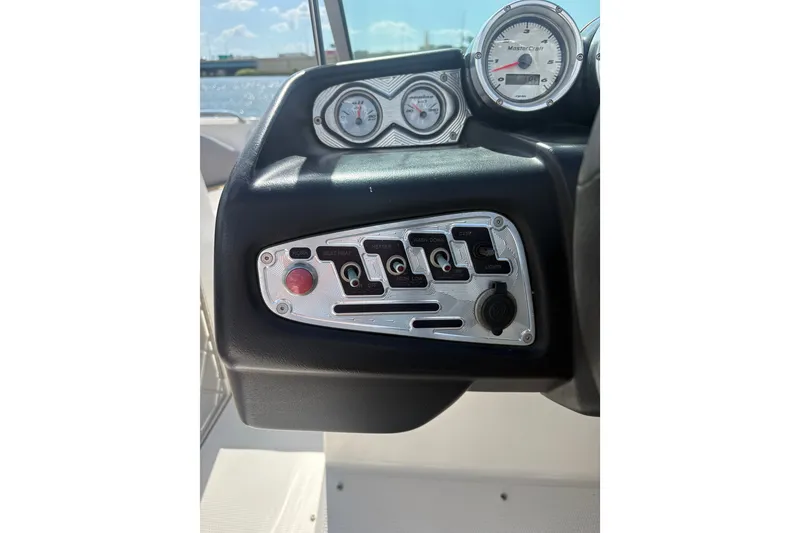 Slide: The Image of Dashboard controls of a 2007 MasterCraft X-15 SS boat with gauges and switches. - 13