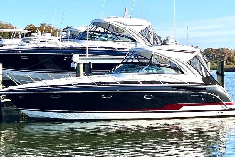 Slide: The Image of 2016 Formula 37 Performance Cruiser docked at marina, sleek design, black and white exterior. - 2