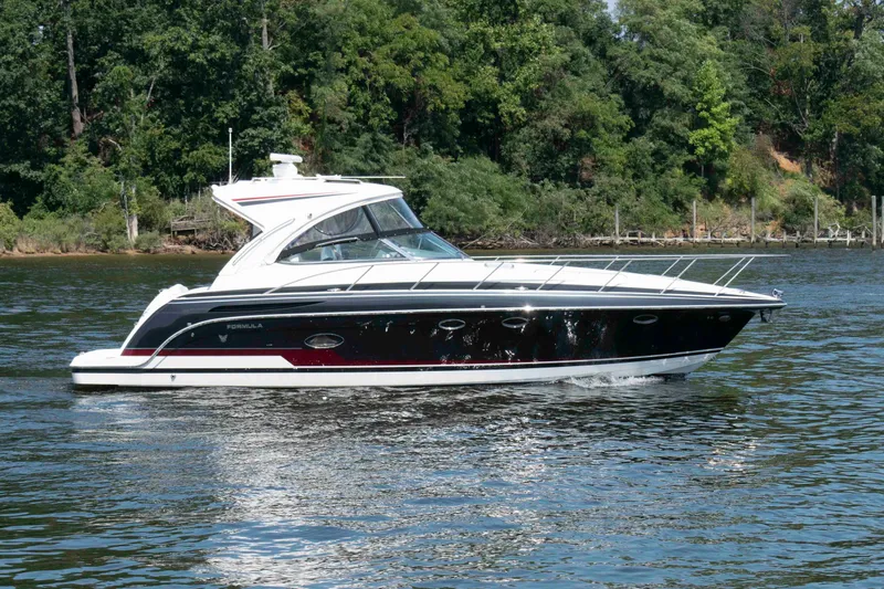The Image of 2016 Formula 37 Performance Cruiser on a serene lake with lush green trees. - 0