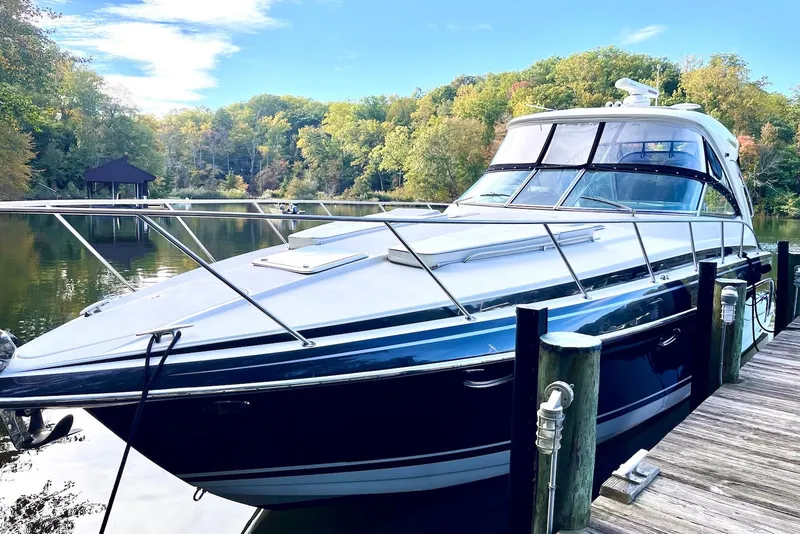 The Image of 2016 Formula 37 Performance Cruiser docked by a scenic, wooded shoreline. - 0