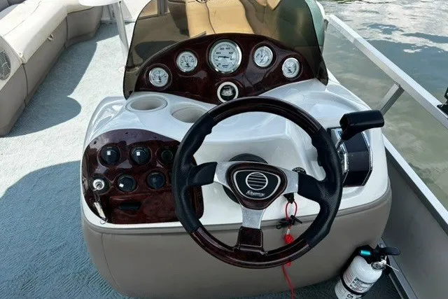 Slide: The Image of 2004 Sun Tracker Party Barge 22 I/O Regency Edition steering console with gauges and controls. - 20